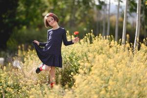 Little girl walking in nature field wearing beautiful dress photo