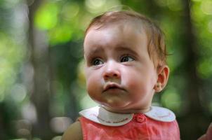 Six months old baby girl having fun outdoors. photo