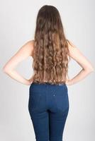 Woman with long hair wearing white t-shirt and blue jeans photo