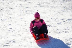 Little girl sledding at Sierra Nevada ski resort. photo