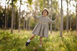 Little girl in nature field wearing beautiful dress photo