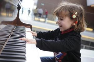 little girl having fun playing the piano photo