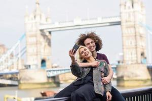 Happy couple taking selfie photograph at the Tower Bridge photo