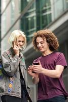 Happy couple using smartphone in urban background. photo