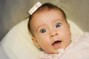 Little baby girl with surprise expression on her face photo