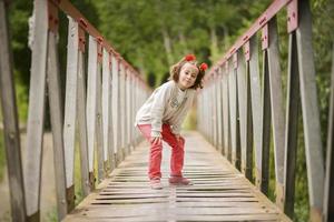 Cute little girl having fun in a rural bridge photo