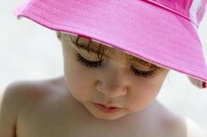 Close-up potrait of adorable little girl wearing sun hat photo