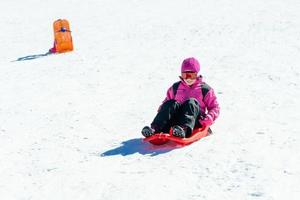 niña en trineo en la estación de esquí de sierra nevada. foto