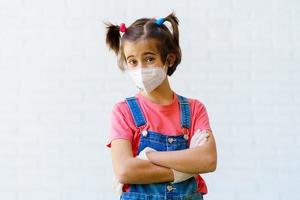 Child girl wearing a protection mask against coronavirus during Covid-19 pandemic photo