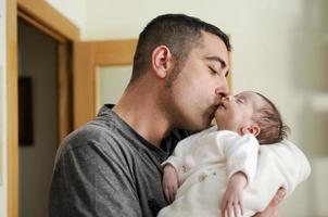 Father kissing his newborn baby girl. photo