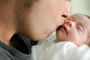 Father kissing his newborn baby girl. photo