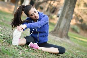 Feliz joven estiramiento antes de correr al aire libre foto