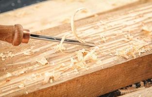 Cincel, tablas de madera y aserrín en el taller de carpintería foto