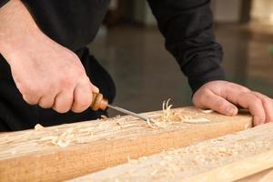 Carpenter working with chisel, closeup photo