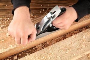 Carpenter working with smoothing plane, closeup photo