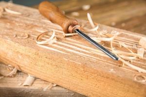 Cincel, tablas de madera y aserrín en el taller de carpintería foto