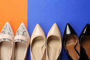 Elegant female shoes on color background photo