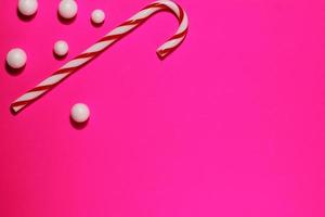 Red striped cane, Christmas candy on magenta background photo