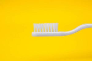 Cepillo de dientes blanco sobre fondo amarillo foto