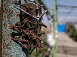 rusty screws on the magnet on the iron pole in the street