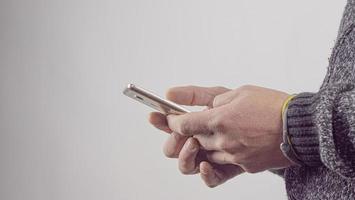 Close-Up Of Male Hands Holding A Mobile Phone. Man Uses A Mobile Phone. High Quality Photo