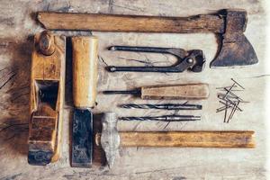 Old construction tools on a wooden workbench flat lay background photo