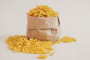 Spiral pasta in a paper bag on a white background photo