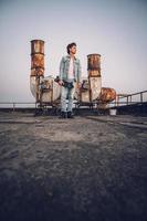 Man with skateboard on a background of rusty pipes photo