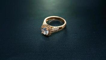 Foto de anillo de mujer con diamantes gemas sobre un fondo negro