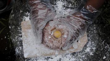 un joven chef está haciendo masa de relleno de hamburguesas en el borde de una cascada foto