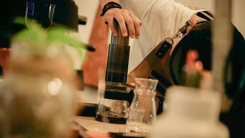 Un barista masculino haciendo café con el método aeropress. foto