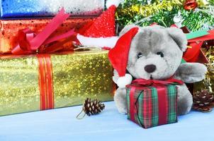 Muñeco de peluche con gorro de Papá Noel y caja de regalo y fondos de adornos navideños