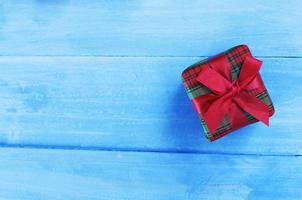 Caja de regalo verde rojo sobre fondos de madera de color azul pastel para el concepto de vacaciones de Navidad