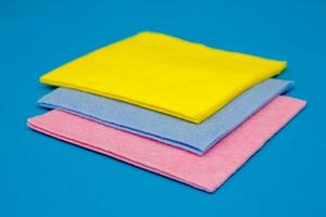 Multicolored cleaning rags on blue background photo