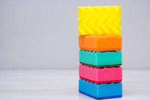 Multicolored sponges for cleaning and washing dishes on a white table photo