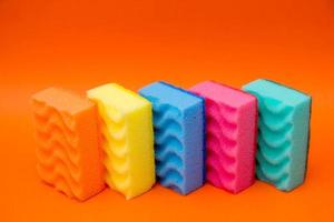 Multicolored sponges for cleaning on a orange background