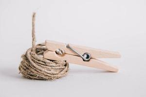 Wooden clothespin and rope on white background photo