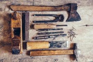 Old construction tools on a wooden workbench flat lay background photo