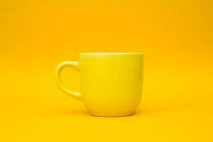 Taza de cerámica amarilla sobre fondo amarillo foto