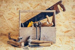 caja de herramientas de madera vieja llena de herramientas. herramientas de carpintería antiguas foto
