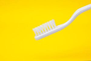 White toothbrush on yellow background photo