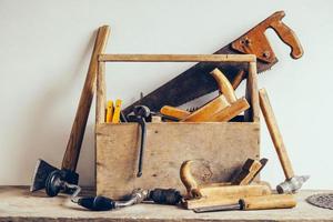 caja de herramientas de madera vieja llena de herramientas. herramientas de carpintería antiguas foto