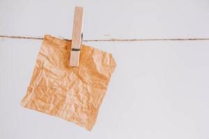 Brown stickers on clothesline with wooden clothespin on white background