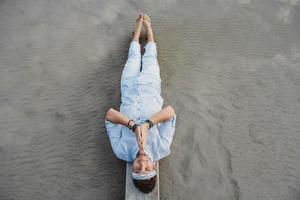 Man lying on wooden bridge against background of water photo
