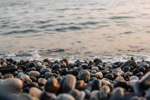 Small stones by the sea with bokeh effect. Blurred decorative background, place for text photo