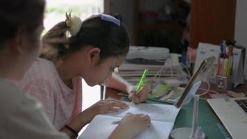 Woman helping teen girl doing her homework