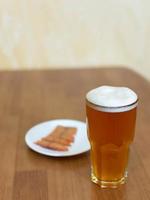 Beer in a glass on the table and a plate with fish photo