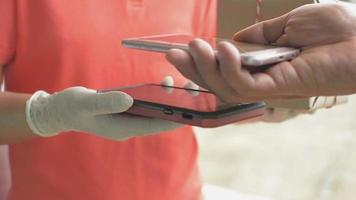 Close up of hands using smartphones to scan QR code payment video