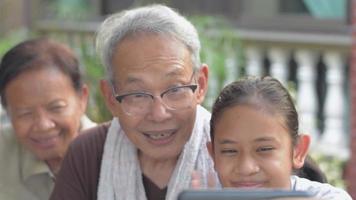 Girl and her grandparents using video call from smartphone.