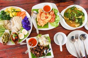 Vista superior de comida tailandesa comida asiática servida en mesa de madera con menú de placa en Tailandia foto